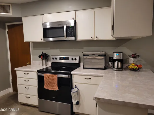 a kitchen with stainless steel appliances granite countertop a stove microwave and cabinets
