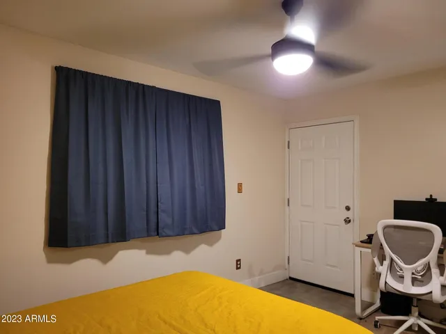 a bedroom with a bed and a ceiling fan