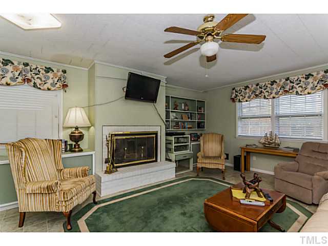109 North King Charles Road Raleigh, NC 27610 - Photo 11 of 22 a living room with furniture a fireplace and a flat screen tv