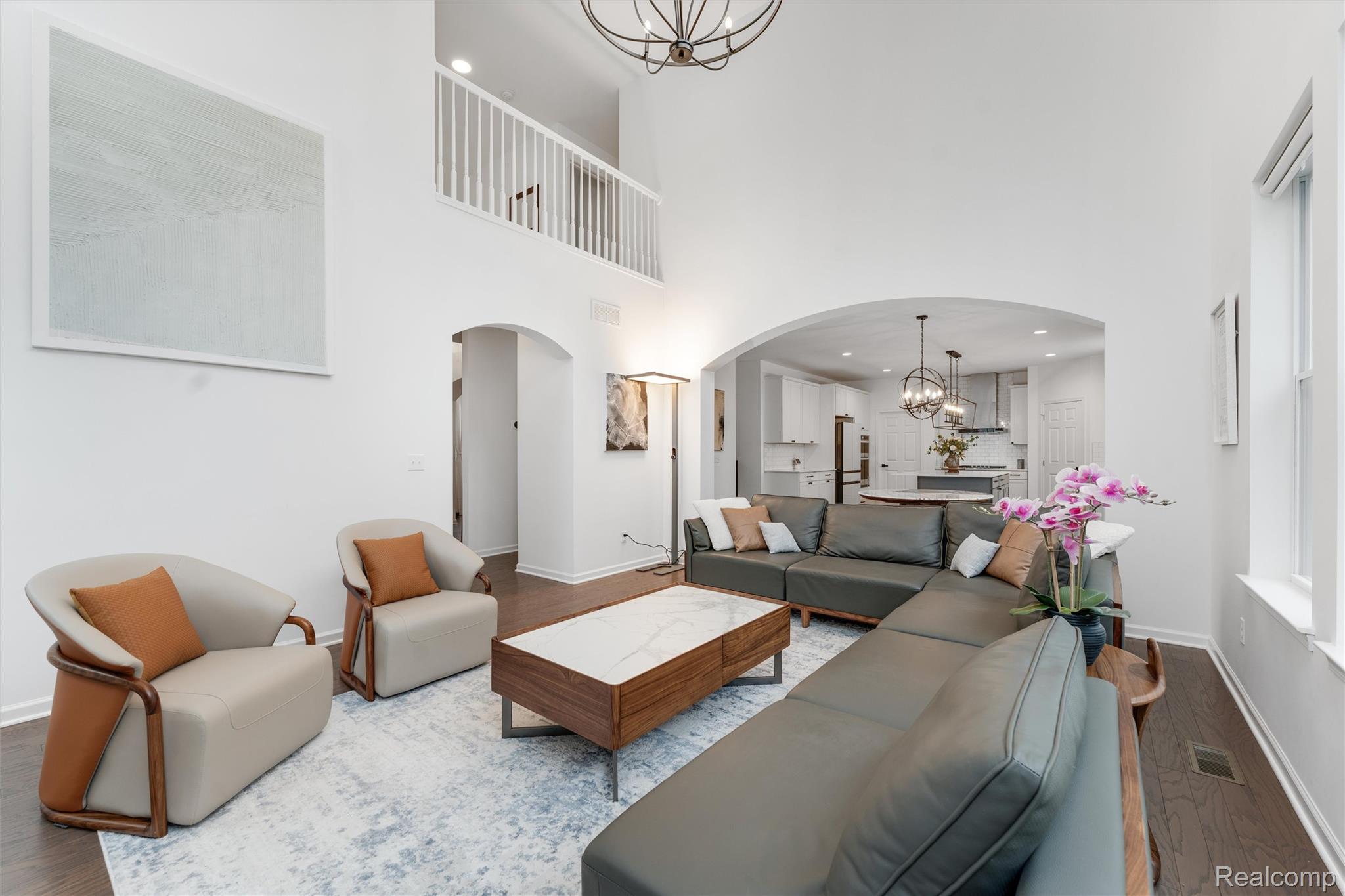 908 South Livernois Road Rochester, MI 48309 - Photo 14 of 49 Living room featuring a chandelier, arched walkways, wood finished floors, and a high ceiling