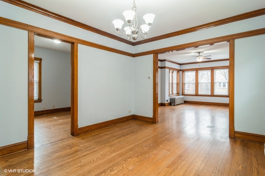 3935 North Christiana Avenue, Unit 2 Chicago, IL 60618 - Photo 3 of 12 a view of an empty room with wooden floor and a window