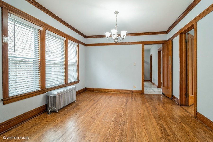 3935 North Christiana Avenue, Unit 2 Chicago, IL 60618 - Photo 4 of 12 a view of an empty room with wooden floor and a window