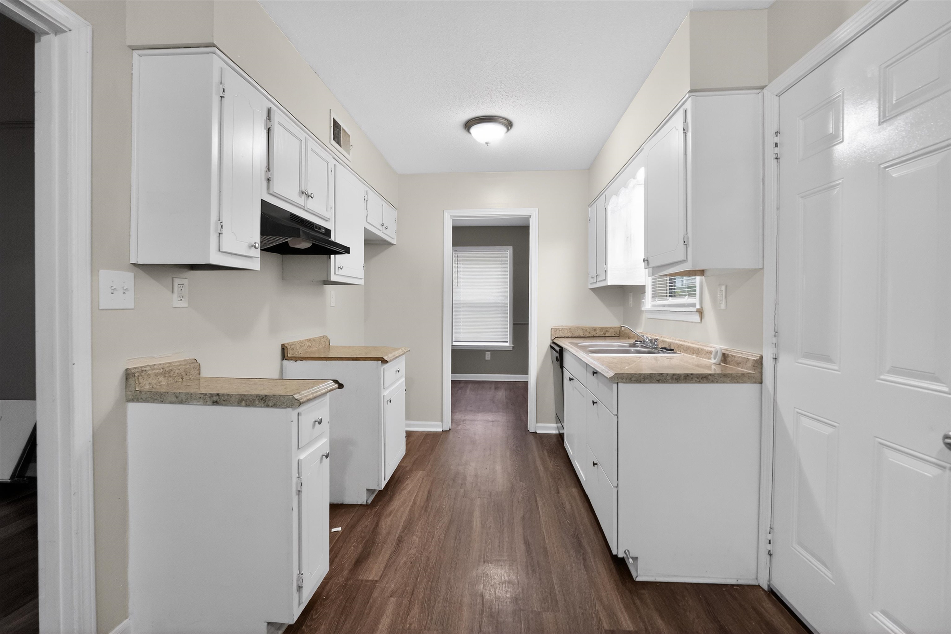 3152 Mackham Avenue Memphis, TN 38118 - Photo 12 of 16 Kitchen featuring white cabinetry, light-colored countertops, dark wood-finish flooring, and a window for natural light