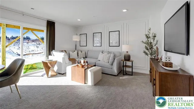 a living room with furniture a chandelier and a flat screen tv