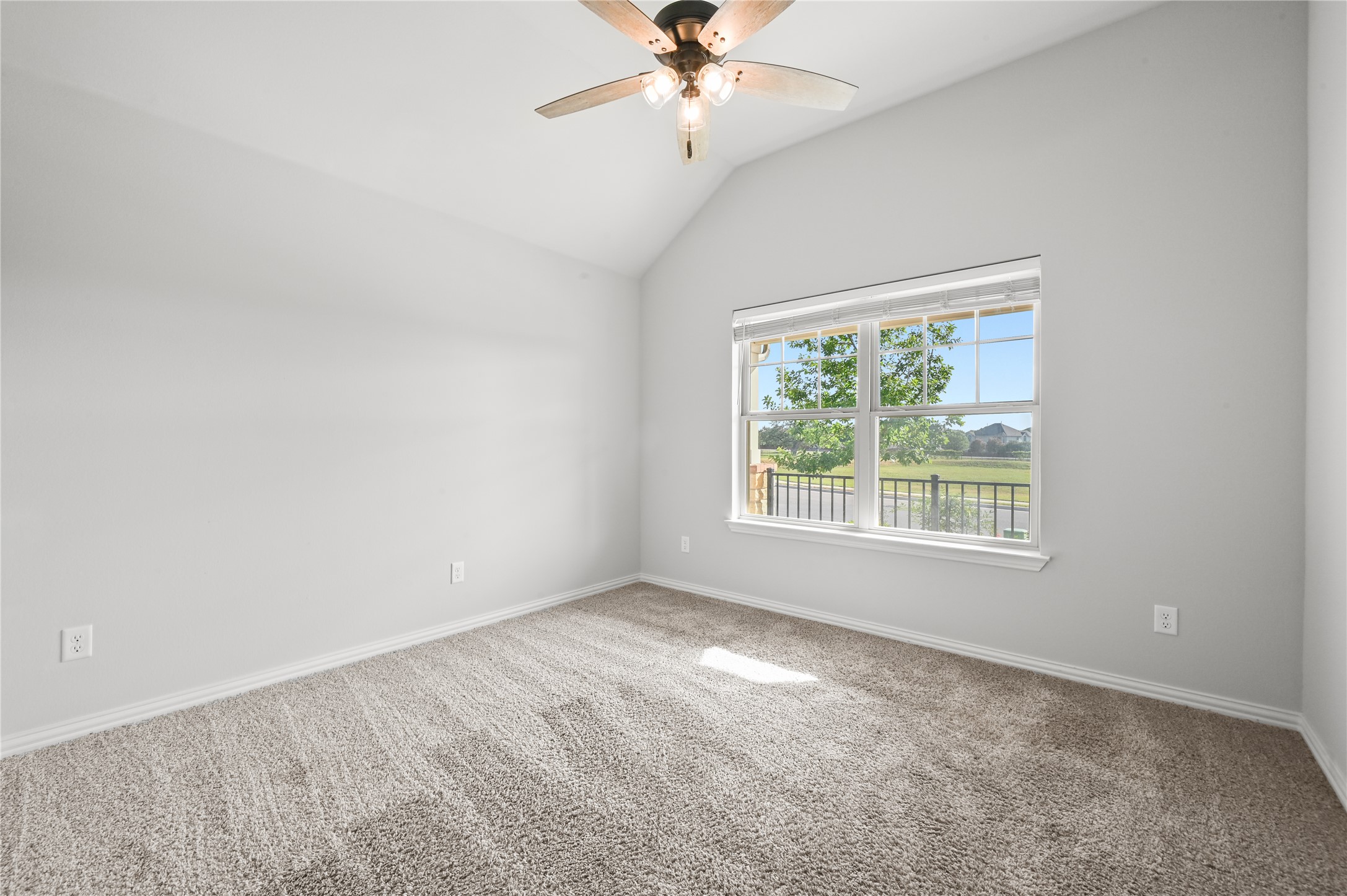 426 Cold Riv Run Kyle, TX 78640 - Photo 25 of 34 A well-lit bedroom with vaulted ceilings and a window providing views of the surrounding landscape.