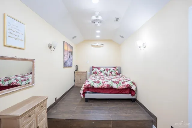 a bedroom with bed and paintings on the wall