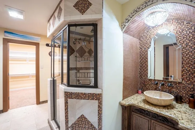 a bathroom with a granite countertop sink and a mirror
