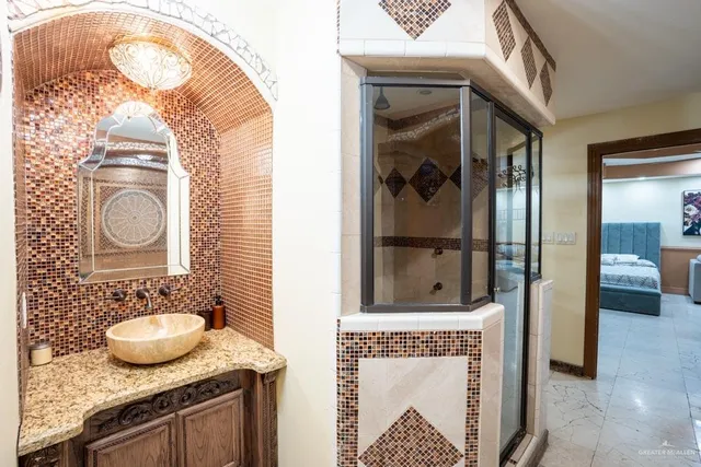 a bathroom with a granite countertop sink a mirror and a shower