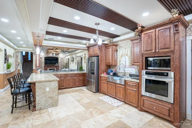 a kitchen with stainless steel appliances kitchen island granite countertop a table and chairs in it
