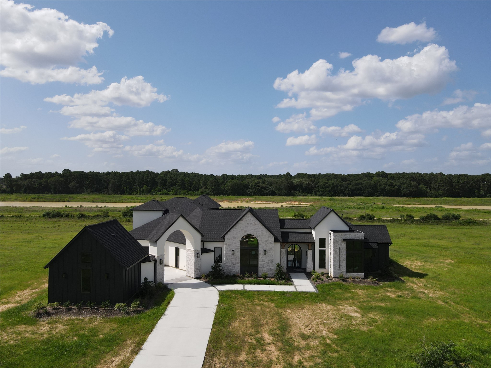 20218 Tealpointe Ridge Lane Tomball, TX 77377 - Photo 2 of 50 a view of a house with a garden and lake view