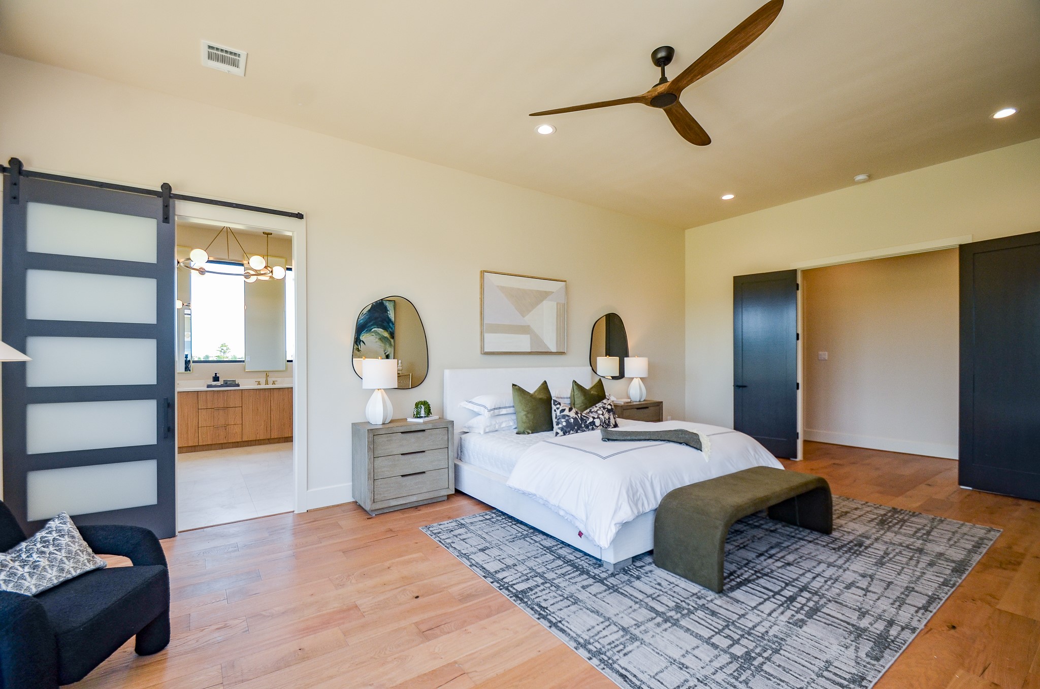 20218 Tealpointe Ridge Lane Tomball, TX 77377 - Photo 24 of 50 a bedroom with a large bed and a chandelier