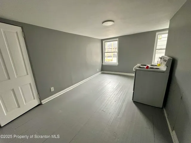 a view of room with window and wooden floor