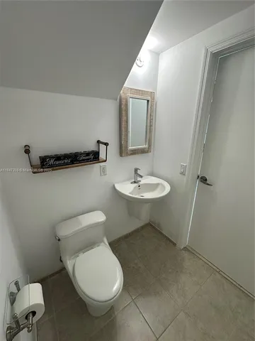 a bathroom with a toilet a sink and mirror