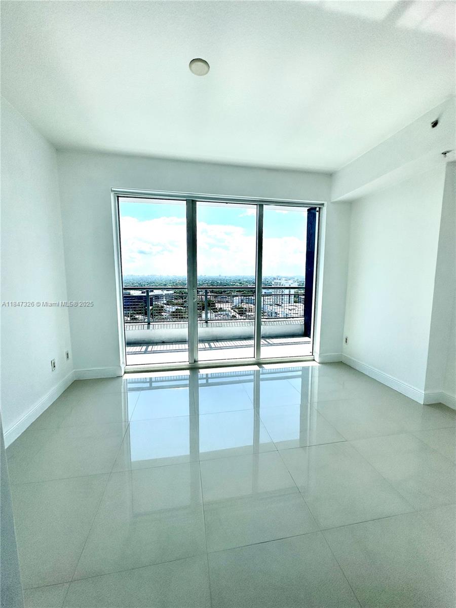 60 Southwest 13th Street, Unit 1605 Miami, FL 33130 - Photo 8 of 28 an empty room with large windows
