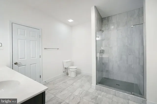 a bathroom with a shower a toilet and a sink