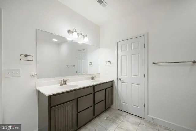 a bathroom with a double vanity sink mirror and