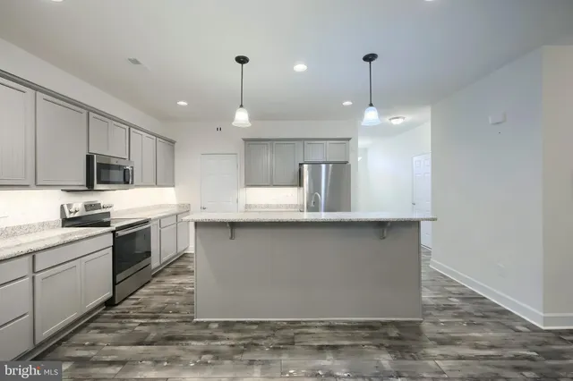 a kitchen with stainless steel appliances granite countertop a sink a stove and a refrigerator