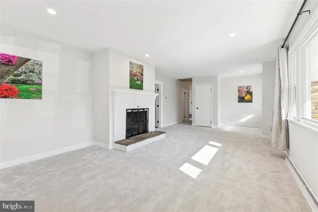 an empty room with windows and fireplace