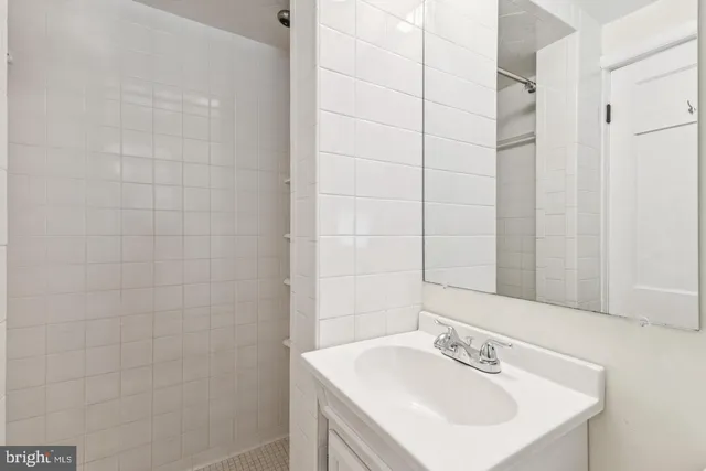 a bathroom with a sink a shower and a mirror