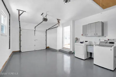 a view of a kitchen with washing machine and cabinets