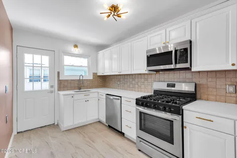 a kitchen with granite countertop cabinets stainless steel appliances and a window