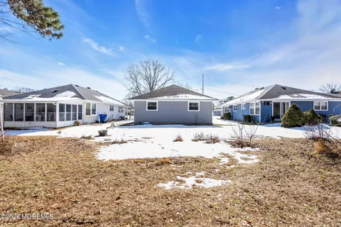 a front view of a house with a yard covered in snow