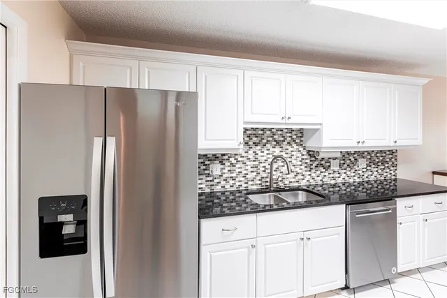 a kitchen with stainless steel appliances granite countertop a refrigerator and a sink