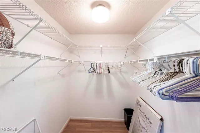 a view of walk in closet with clothes and white walls