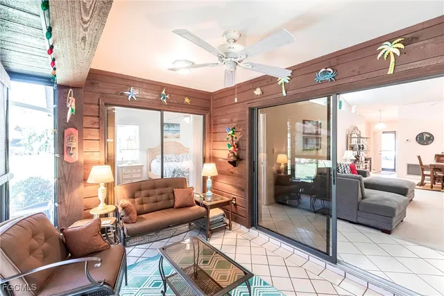 a living room with furniture a ceiling fan and a large window