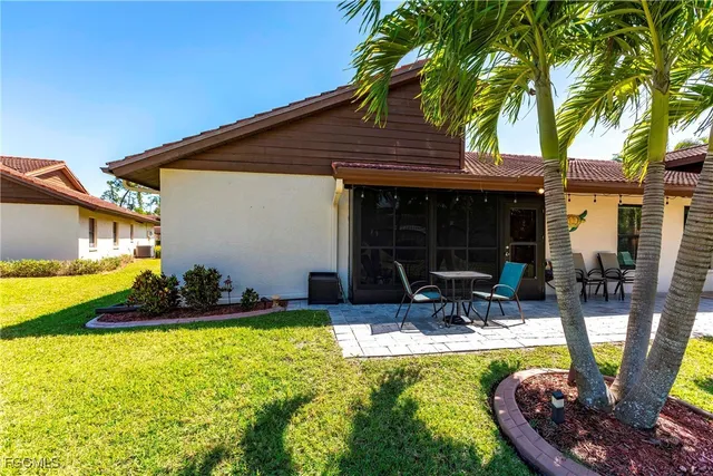 a view of a swimming pool with chairs and plants