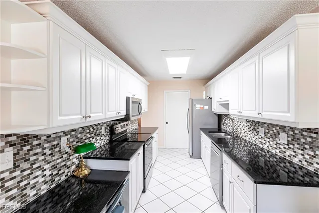 a kitchen with granite countertop a stove a sink and a cabinets