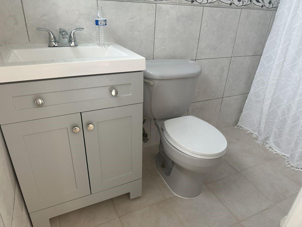 4610 Peters Road Plantation, FL 33317 - Photo 5 of 8 a white toilet sitting next to a bathroom sink