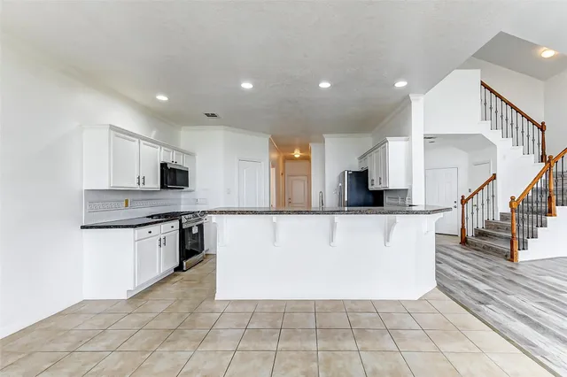 a view of kitchen with stainless steel appliances granite countertop a refrigerator oven a sink and dishwasher