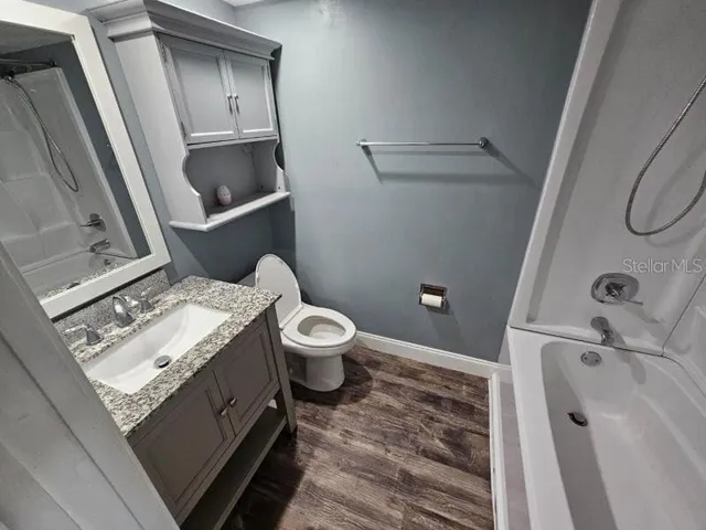 a bathroom with a granite countertop sink toilet and shower