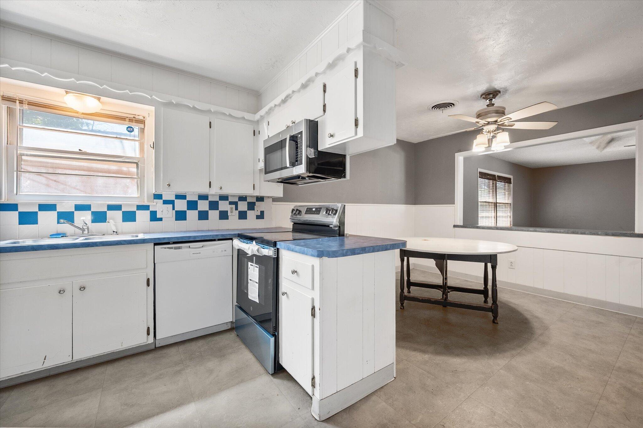 4604 27th Street Lubbock, TX 79410 - Photo 25 of 36 a kitchen with granite countertop a sink white cabinets and stainless steel appliances