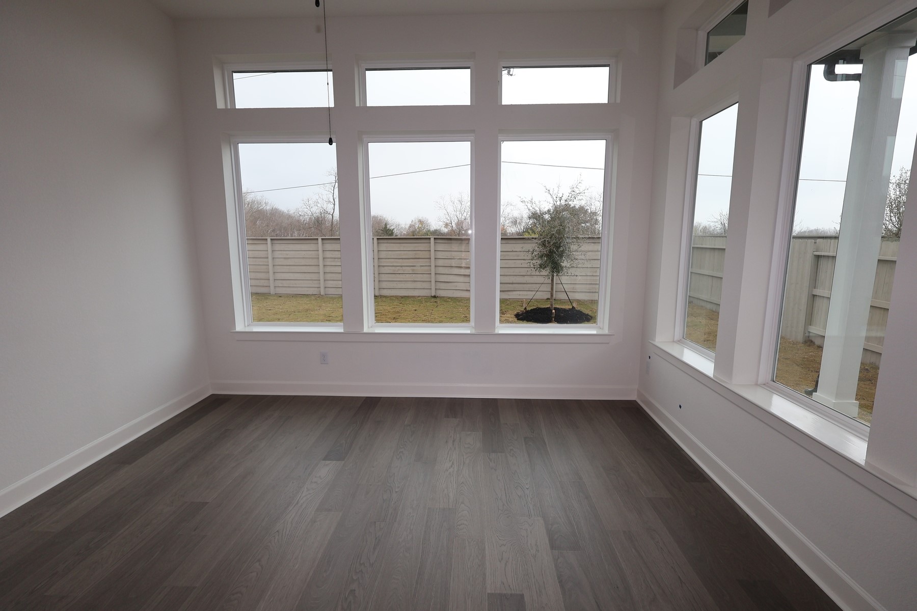 5614 Orangery Lane Manvel, TX 77578 - Photo 8 of 19 an empty room with wooden floor and windows