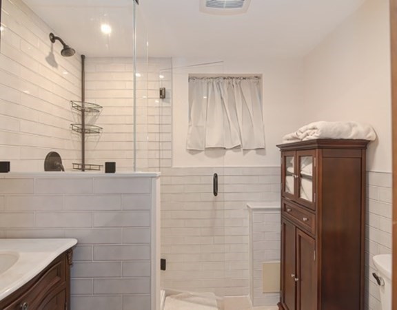 61 Arnold Road Quincy, MA 02171 - Photo 22 of 33 a bathroom with a granite countertop sink a vanity and a shower
