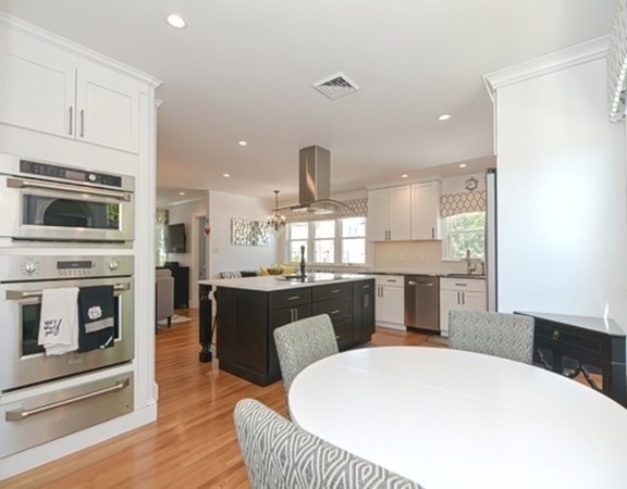 61 Arnold Road Quincy, MA 02171 - Photo 4 of 33 a kitchen with stainless steel appliances a dining table chairs stove refrigerator and cabinets