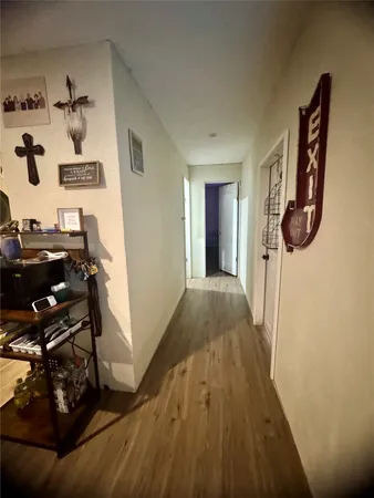 a view of a hallway with wooden floor and a workspace