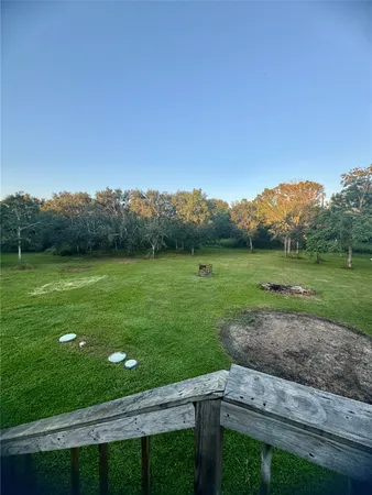 a view of a green field with trees in the background