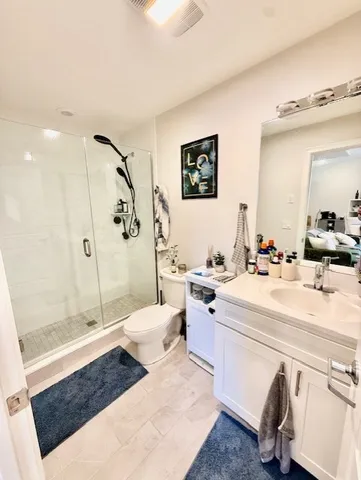 a spacious bathroom with a sink a toilet a mirror and shower