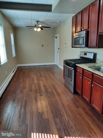 a kitchen with granite countertop wooden floors and stainless steel appliances