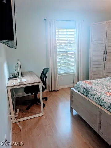 a bedroom with a bed and a flat tv screen on the table
