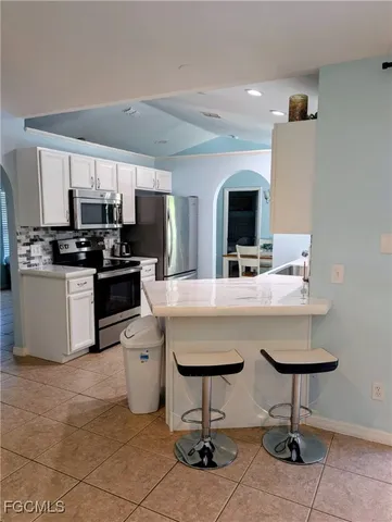 a kitchen with kitchen island a counter space a sink and appliances