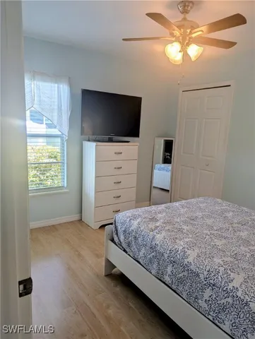 a bedroom with a bed and a flat tv screen on dresser