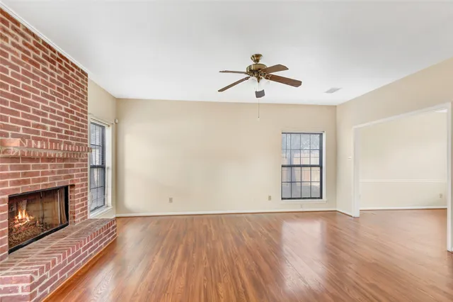 a view of empty room with wooden floor and fireplace