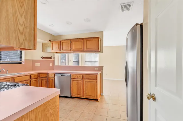 a kitchen with stainless steel appliances granite countertop a refrigerator and a stove top oven