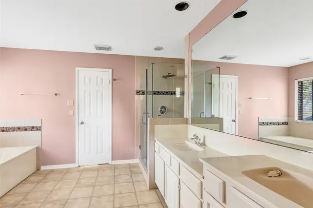 a spacious bathroom with a tub sink and mirror