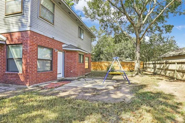 a view of a house with backyard and sitting area