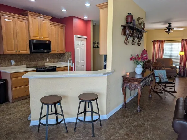 a kitchen with stainless steel appliances a dining table chairs microwave and sink